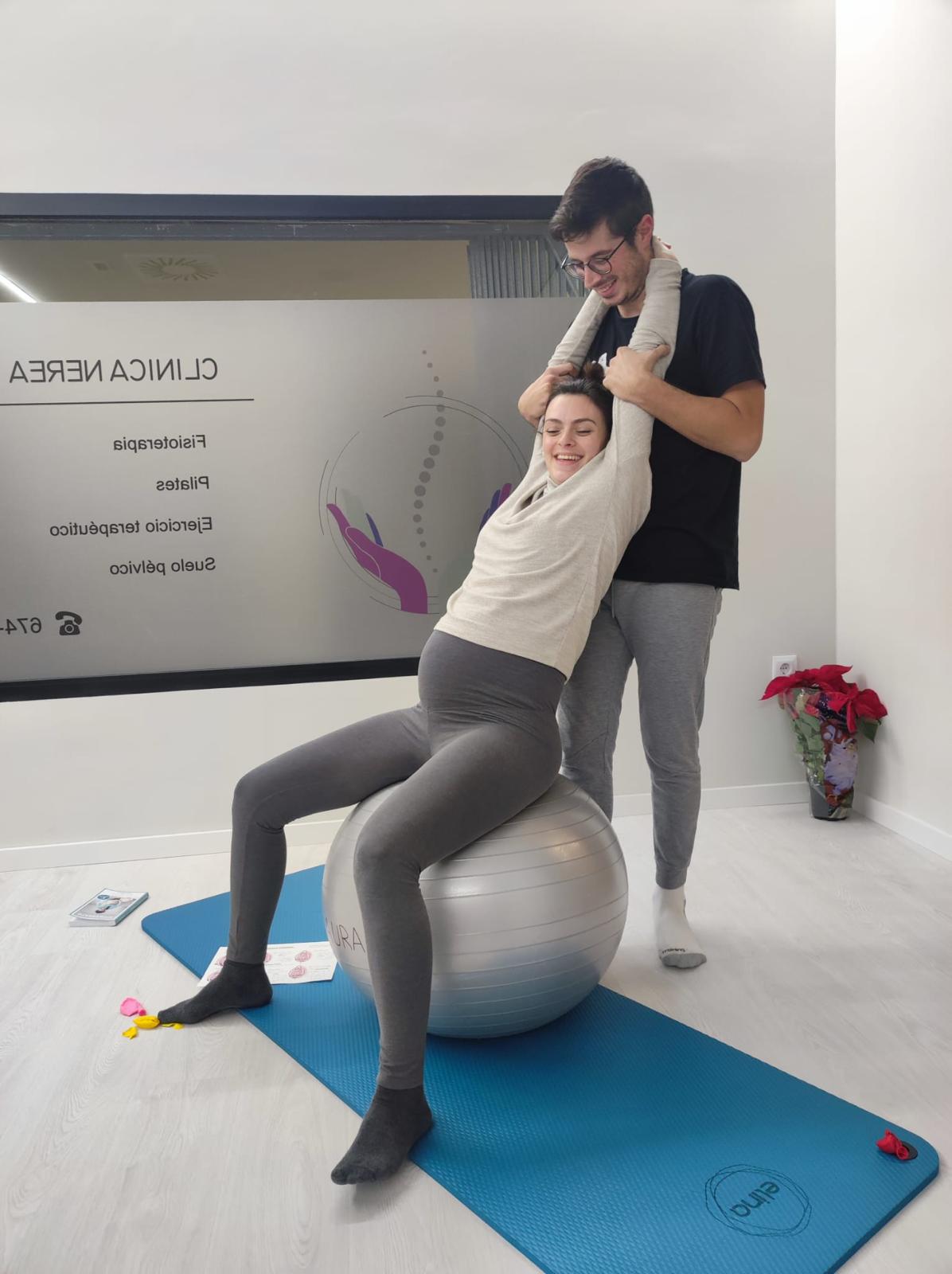 Mujer embarazada haciendo ejercicio con ayuda.