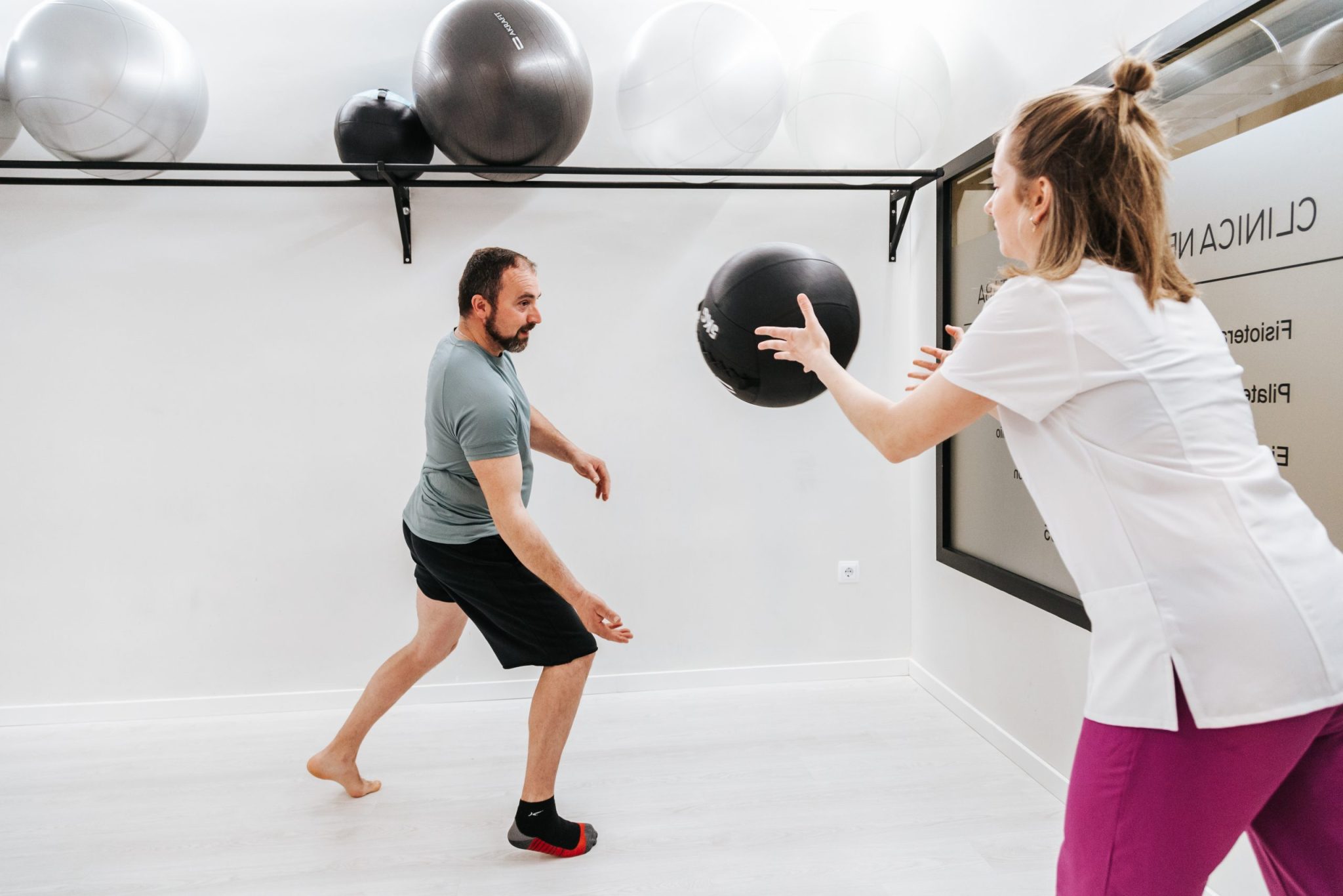 Hombre y mujer entrenando con balón de ejercicio