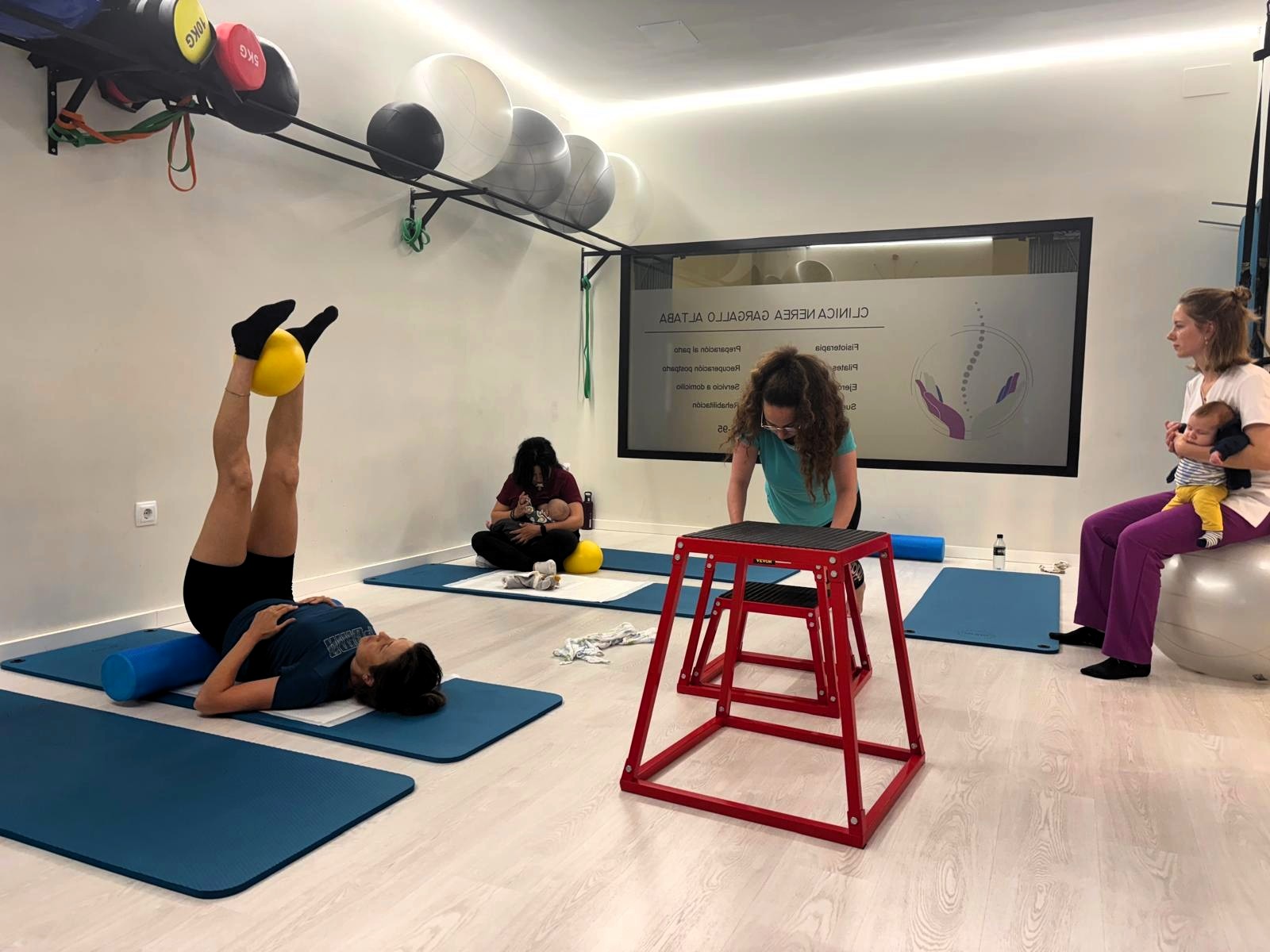 Clase de pilates con diferentes ejercicios y equipamiento.